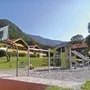 Spielplatz mit Klettergeräten und Rutsche vor Bergkulisse in Oberwössen.
