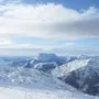 Schneebedeckte Alpenlandschaft mit Berg im Hintergrund.