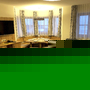 Wohnzimmer mit Sofa, Fernseher, Esstisch und Stühlen, Fenster mit Vorhängen.