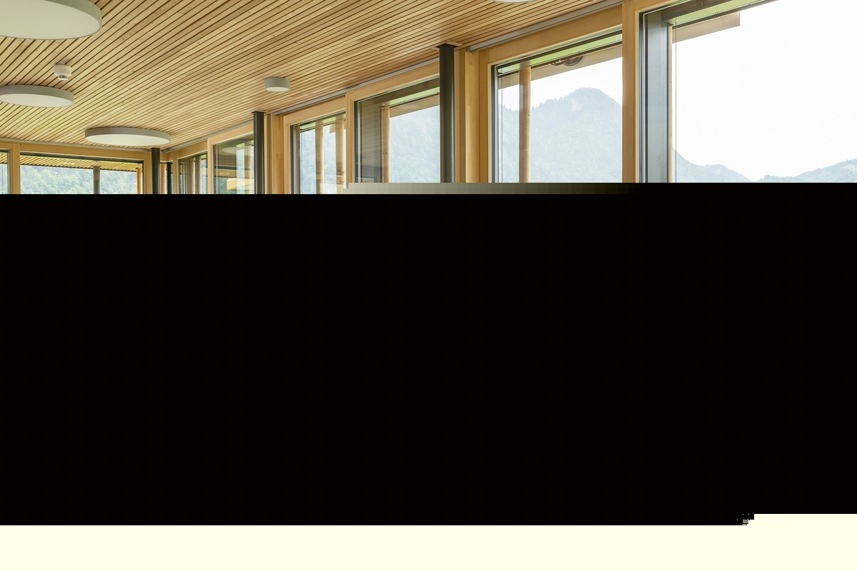 Moderne Restaurant-Innenansicht mit großen Fenstern und Bergblick.