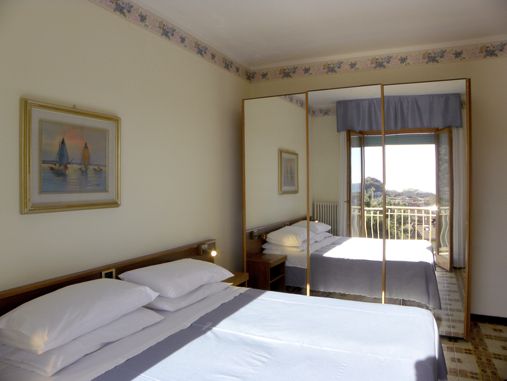 Ein Schlafzimmer mit Doppelbett, großem Kleiderschrank und Fenster mit Aussicht.