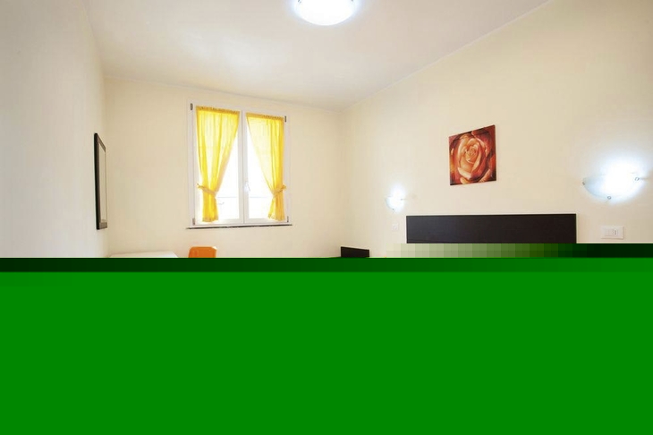 Zimmer mit orangefarbenem Bett und gelben Vorhängen.
