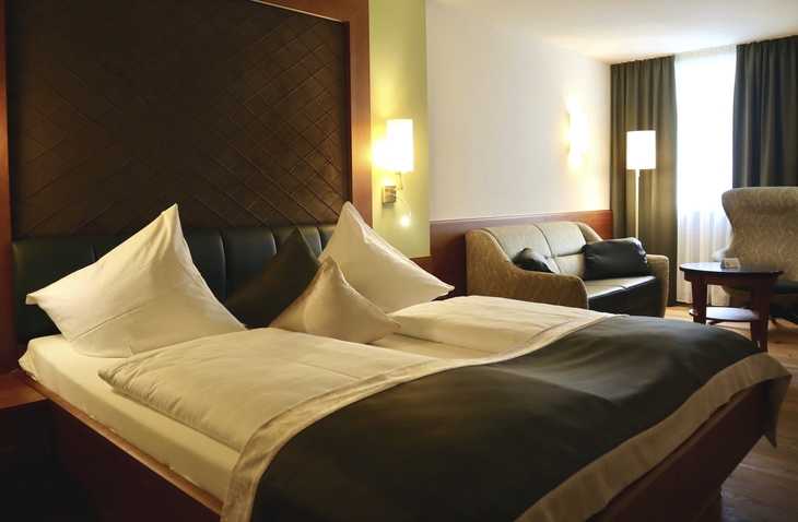 Dreibettzimmer im Hotel mit Doppelbett und Sitzbereich
