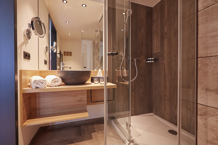 Modernes Badezimmer mit Holzverkleidung, freistehendem Waschbecken und Dusche