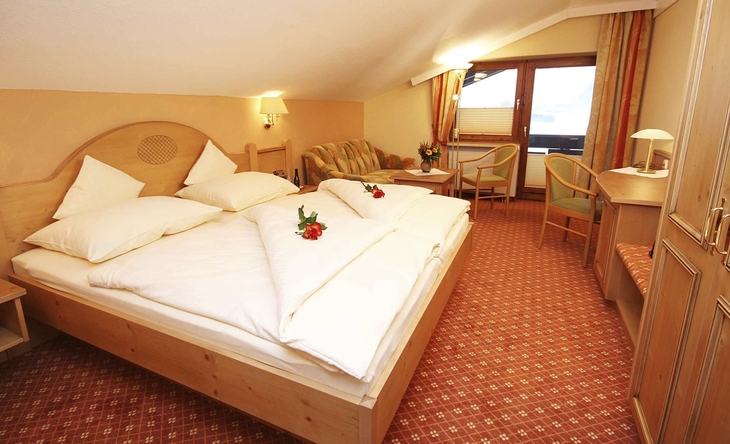 Gemütliches Hotelzimmer mit Doppelbett und Holzdekor.
