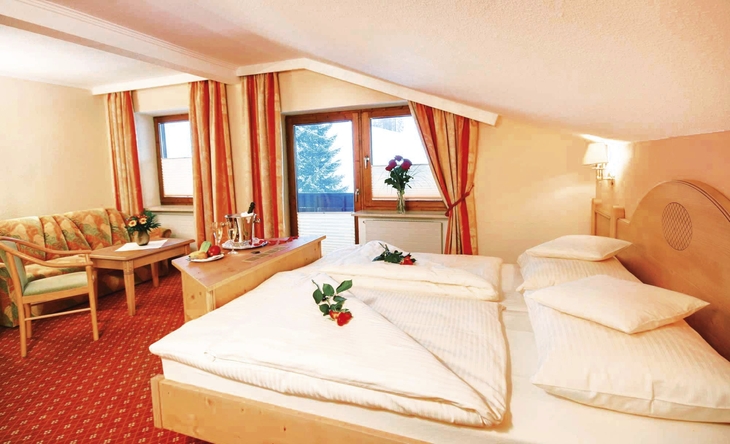 Junior Suite mit Doppelbett, Sitzbereich und Fensterblick im Suitehotel Kleinwalsertal.