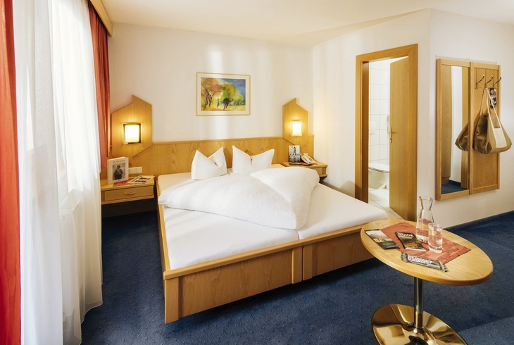 Komfortables Doppelzimmer mit Doppelbett und moderner Einrichtung in Hotel Wiese.