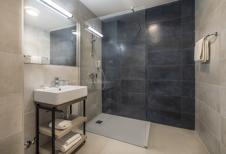Modernes Badezimmer mit Dusche, Waschbecken und Handtuch.