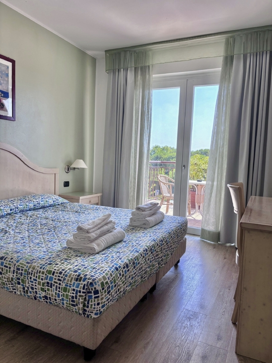 Helles Doppelzimmer mit Balkon im Hotel Bella Italia.