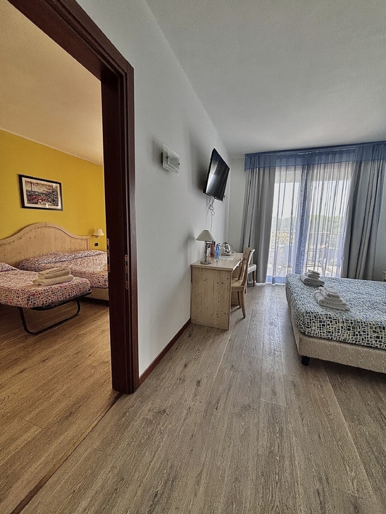 Familienzimmer mit Verbindungstür und zwei Betten im Hotel Bella Italia.
