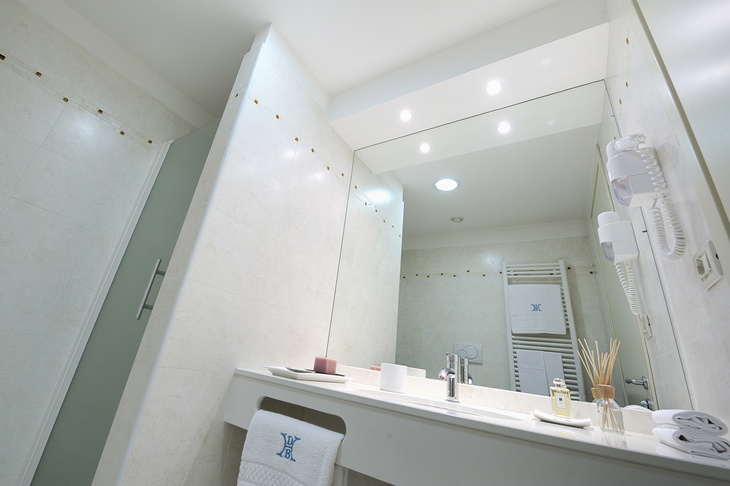 Modernes Badezimmer mit großem Spiegel und Waschtisch.