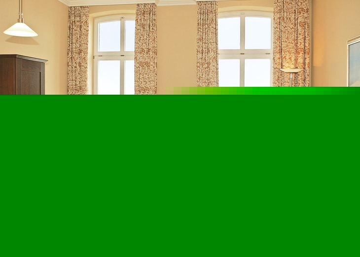 Helles Wohnzimmer mit Ledersofa, Esstisch und Blick durch große Fenster.