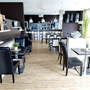 Innenansicht eines modernen, hellen Restaurants mit Holzboden und elegante Einrichtung.