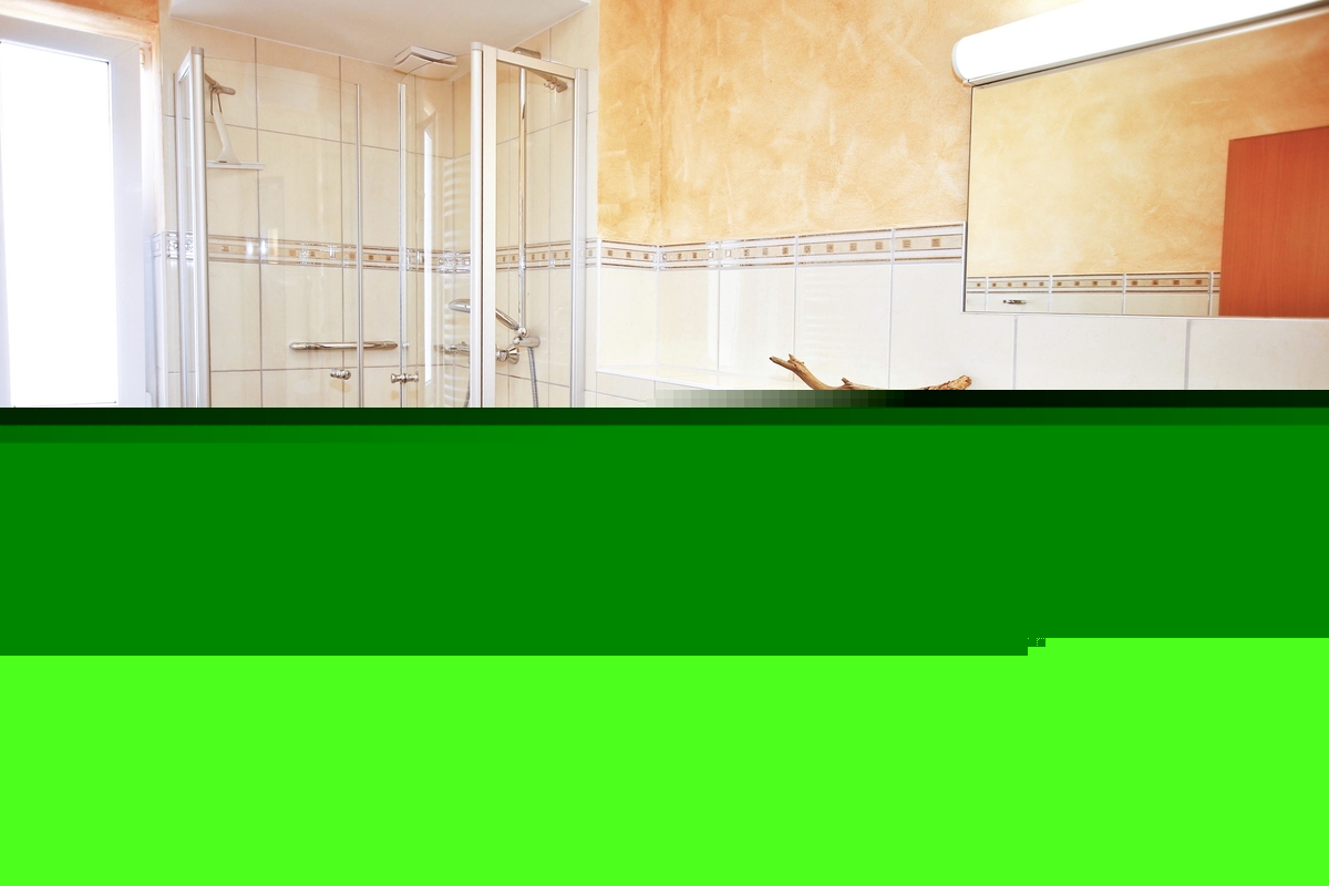 Helles Badezimmer mit Dusche, WC und Waschbecken in einer Ferienanlage.