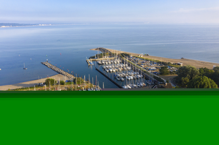 Luftaufnahme des Yachthafens Niendorf mit vielen Booten und klarem Himmel.