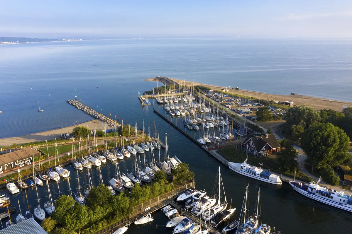 Luftaufnahme des Yachthafens Niendorf mit vielen Booten und klarem Himmel.
