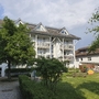 Ferienanlage mit Garten und Wohngebäude am Titisee bei Sonnenschein.