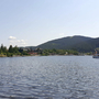 Blick auf den Titisee mit Boot und bewaldeten Hügeln im Hintergrund.