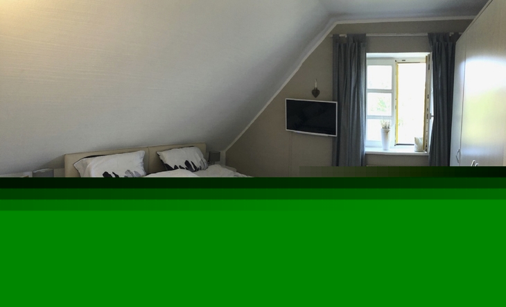 Schlafzimmer mit Doppelbett und hellem Fenster im Feriendorf Bakenberg.