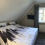 Schlafzimmer mit Doppelbett und hellem Fenster im Feriendorf Bakenberg.