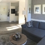 Wohnzimmer einer Ferienwohnung mit Sofa, Esstisch und Kunst an den Wänden.
