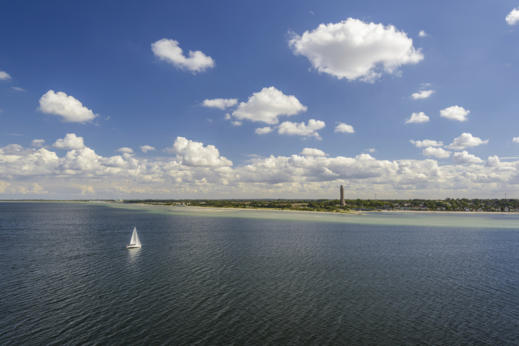 Segelboot auf der Ostsee vor Laboe mit blauem Himmel und Wolken.