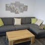 Graues Ecksofa mit Kissen und Couchtisch in modernem Wohnraum.