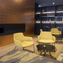Moderne Lounge mit gelben Sesseln und Wandregal, Kamin an der Wand.
