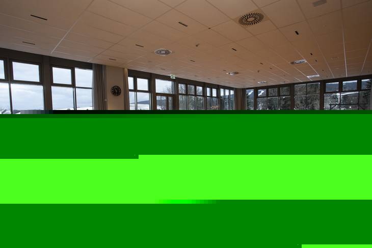 Speisesaal mit Holzstühlen und gedeckten Tischen, große Fenster, Blick ins Freie.