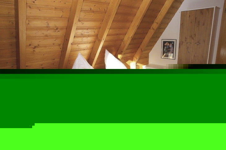 Holzvertäfeltes Schlafzimmer mit Doppelbett und Nachttischlampen.
