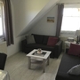 Wohnzimmer mit zwei Sofas, Couchtisch und Fenstern im Reethaus Boddenblick.