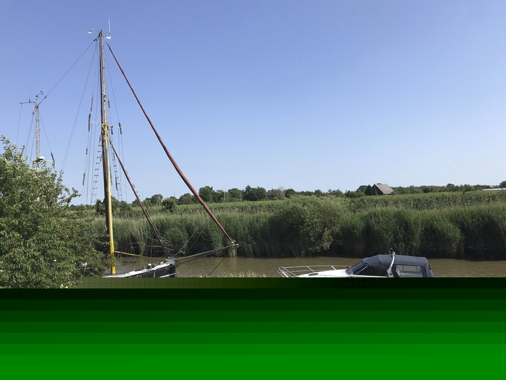 Zwei Boote im Wasser vor Schilfkulisse im Feriendorf Altes Land.
