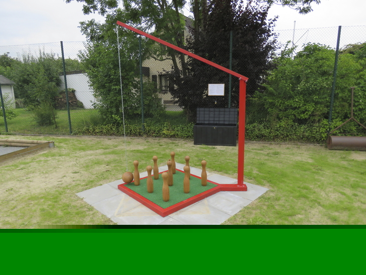 Holzkegelspiel im Freien auf Rasen mit rotem Rahmen.