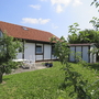 Ferienhaus mit rotem Dach und Garten im Feriendorf Altes Land.