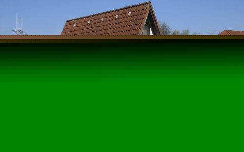 Gelbes Blumenbeet vor einem Holzhaus mit rotem Dach im Feriendorf Altes Land.