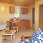 Wohnbereich mit Holzwänden, Küchenzeile und Sofa.