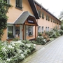 Eingang eines Appartementhauses mit Pflanzen und Gehweg im Feriendorf.
