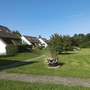 Ferienanlage mit Rasenfläche und weißen Gebäuden im Sonnenschein.