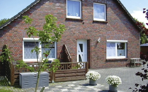 Backstein-Ferienhaus mit zwei Stockwerken und Vorgarten.