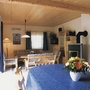Gemütliches Wohnzimmer mit Holzmöbeln, Esstisch und Kaminofen.