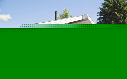 Menschen am Ferienhaus im Grünen mit Fahrrädern und Sonnenschirm.