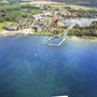 Luftbild eines Ferienparks an einem See mit umliegendem Wald und Bootsanlegestellen.