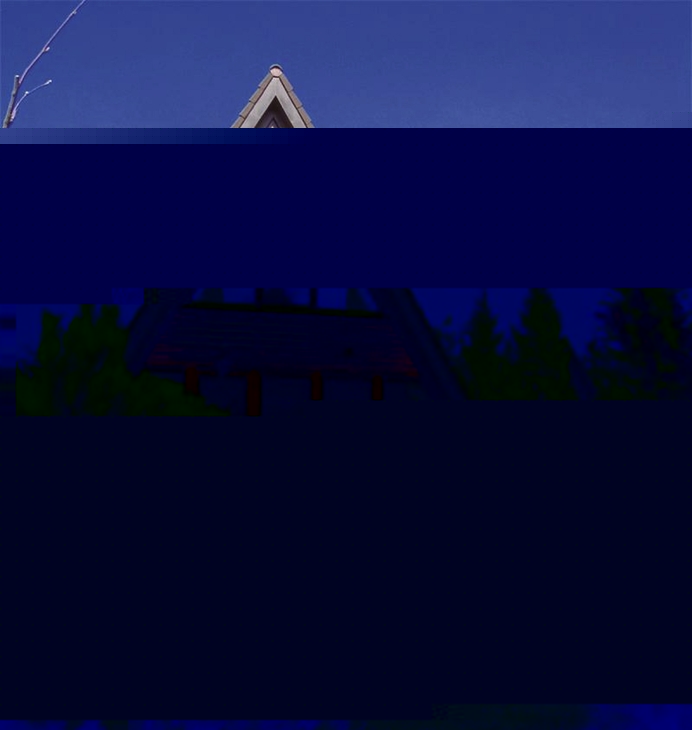 A-förmiges Holzhaus mit Glasfront vor blauem Himmel.