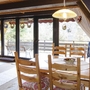 Essbereich in einer gemütlichen Ferienhütte mit Holzstühlen und großem Fenster.