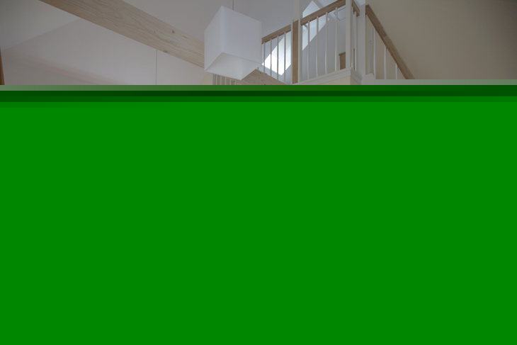 Wohnzimmer mit roten Sitzmöbeln und Blick auf eine Treppe.