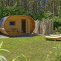 Kleines, hölzernes Ferienhaus mit Liegestühlen im Grünen.