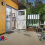 Terrasse mit offenem Türbereich, Spielzeug, Strandkorb und Gartenmöbeln.