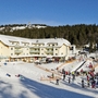 Skigebiet mit Hotel und Skifahrern im verschneiten Schwarzwald, Feldberg.