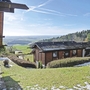 Ferienhäuser im Grünen mit Ausblick auf hügelige Landschaft und Wald.