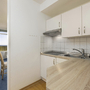 Kleine Küche in Ferienwohnung mit Esstisch und Balkonzugang.